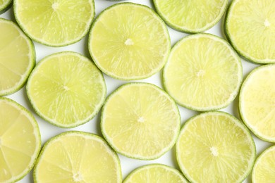 Fresh juicy lime slices on white background, flat lay