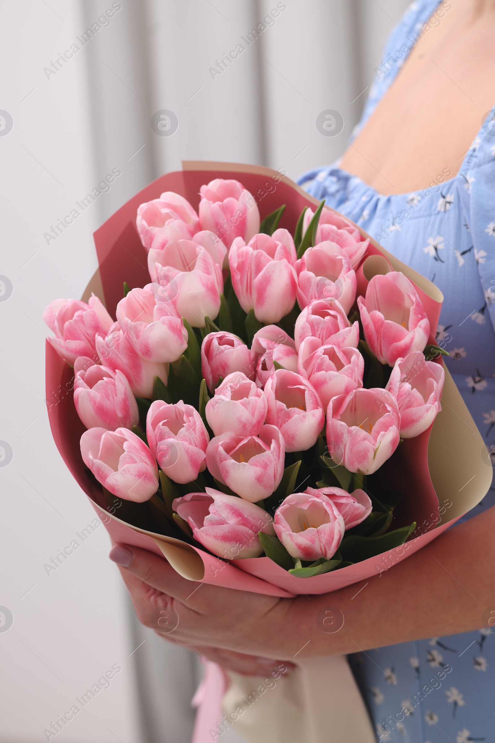 Photo of Woman with bouquet of beautiful fresh tulips on blurred background, closeup