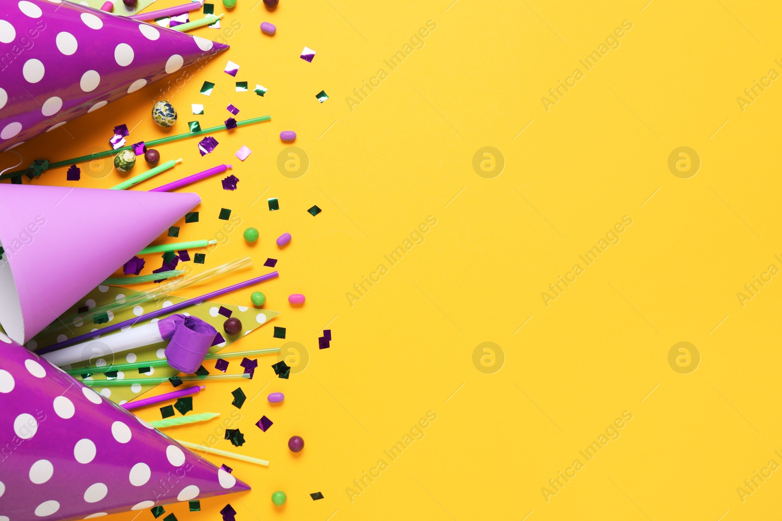 Photo of Flat lay composition with party decor and candies on orange background, space for text