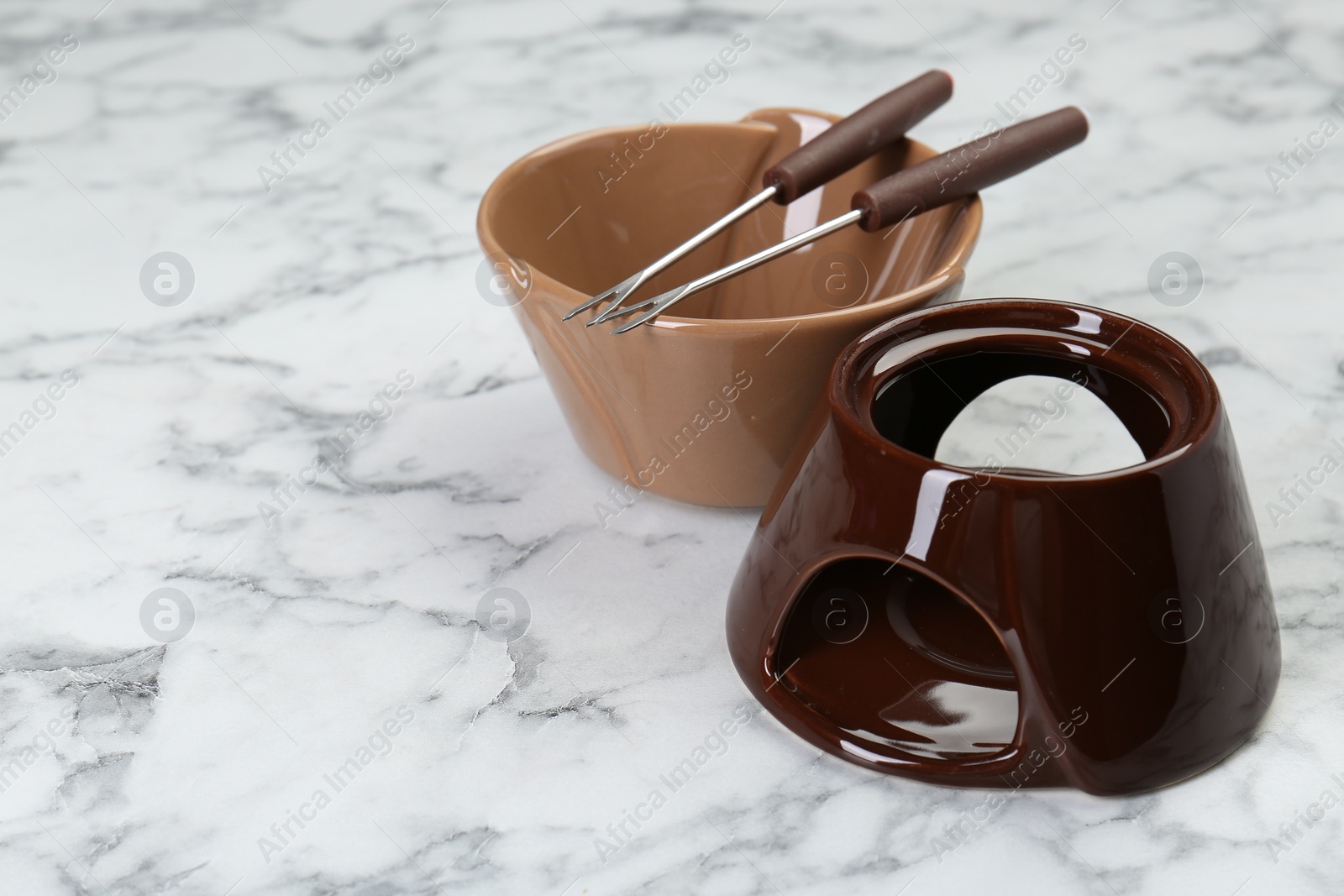 Photo of Fondue set on white marble table, space for text