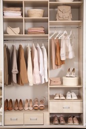 Photo of Modern wardrobe with clothes, shoes and accessories indoors