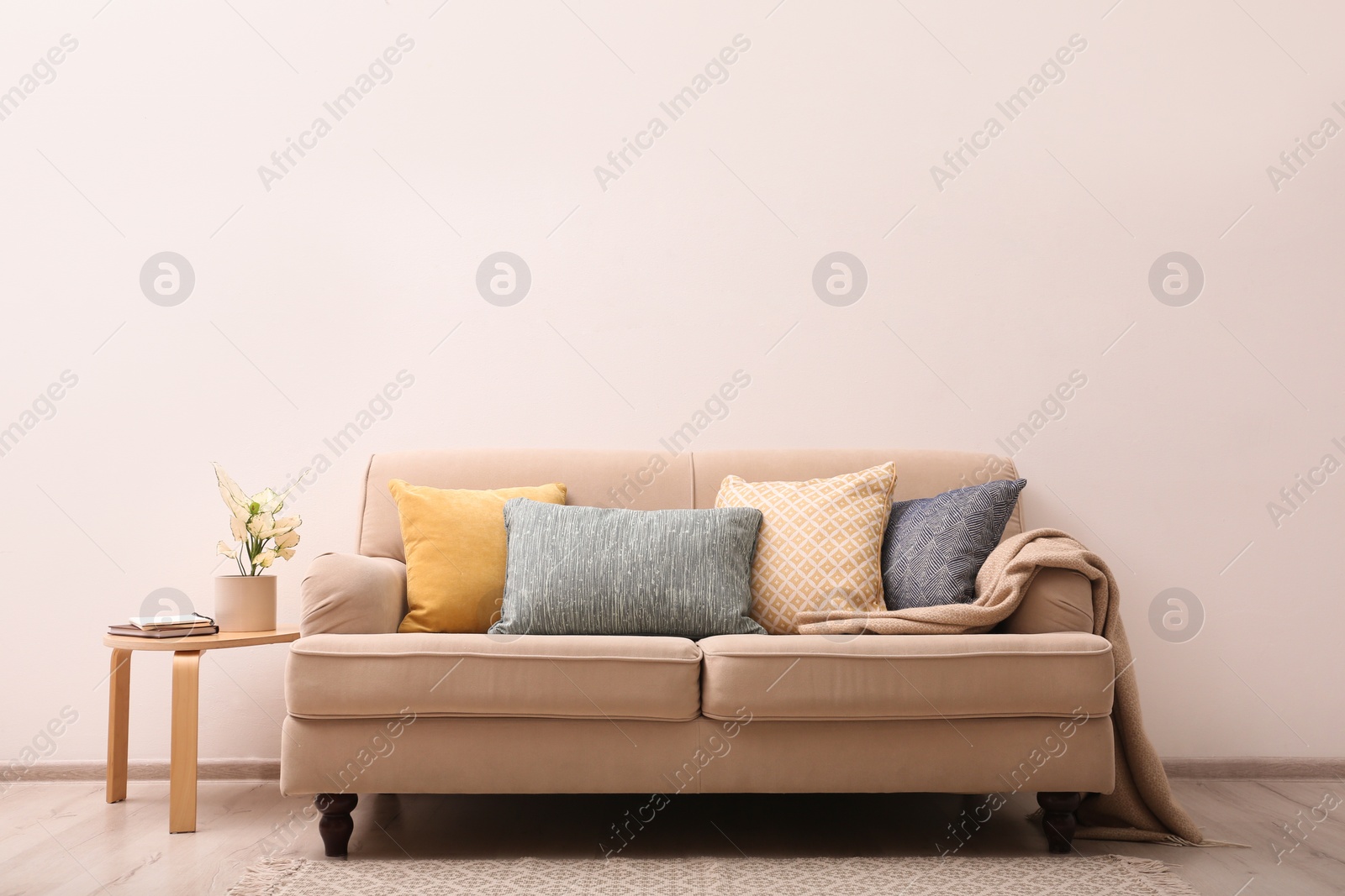 Photo of Simple room interior with comfortable beige sofa, space for text
