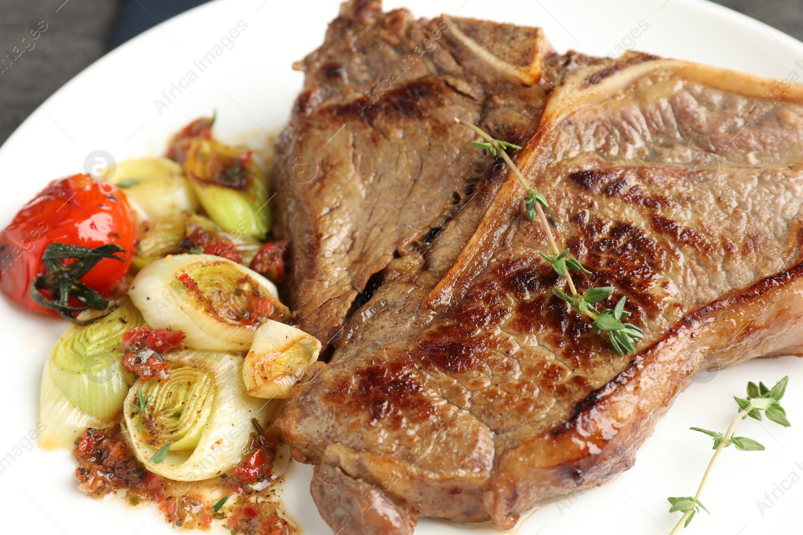 Photo of Delicious fried beef meat and vegetables on plate, closeup