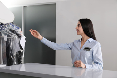 Female worker near counter at modern dry-cleaner's