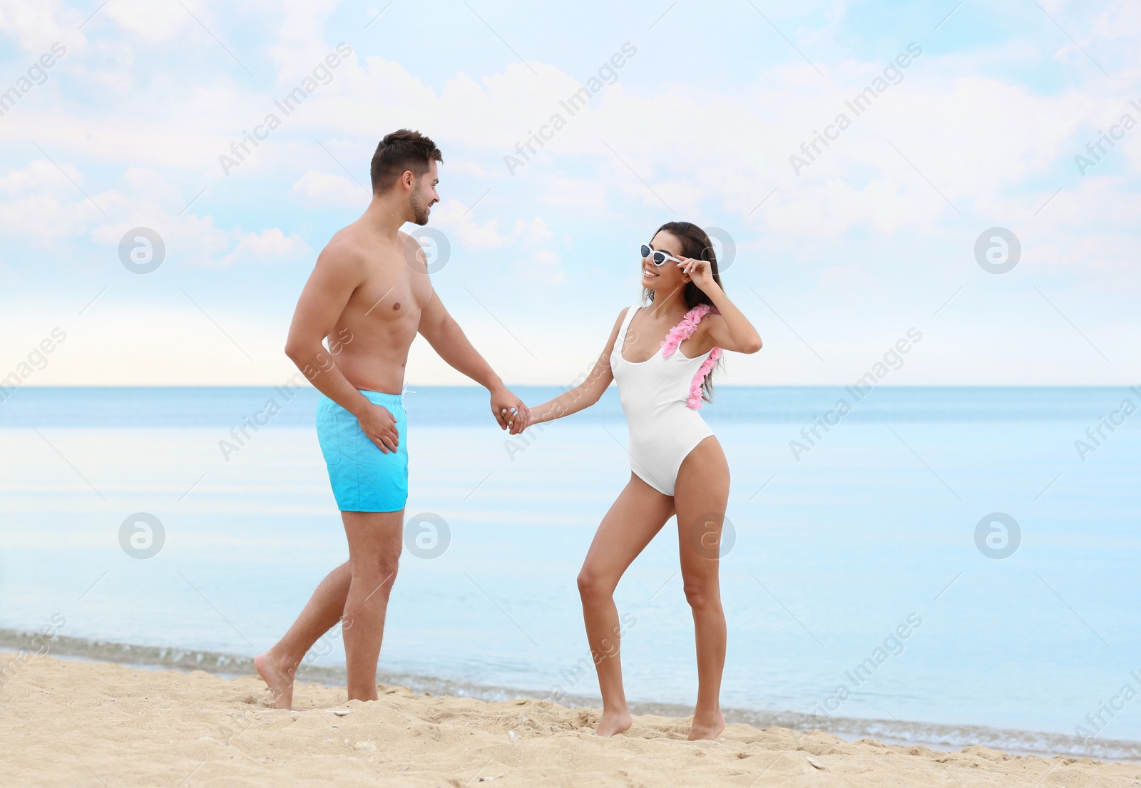 Photo of Happy young couple spending time together on beach near sea