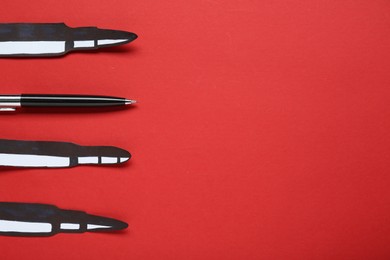 Information warfare concept. Paper bullets and pen on red background, flat lay with space for text