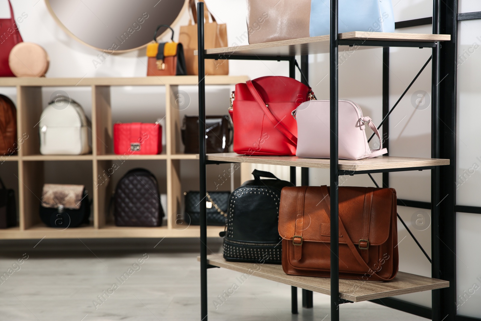 Photo of Collection of stylish woman's bags on rack in store