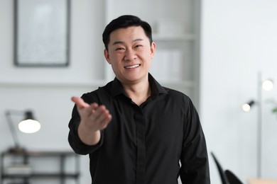 Photo of Portrait of smiling friendly businessman in office