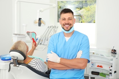 Photo of Professional dentist and patient in modern clinic