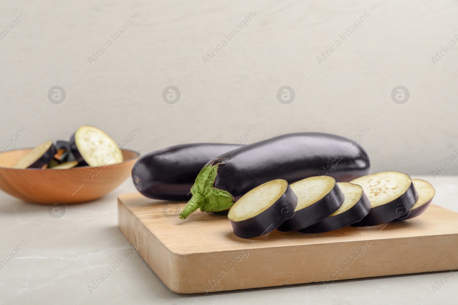 Photo of Wooden board with ripe eggplants on table