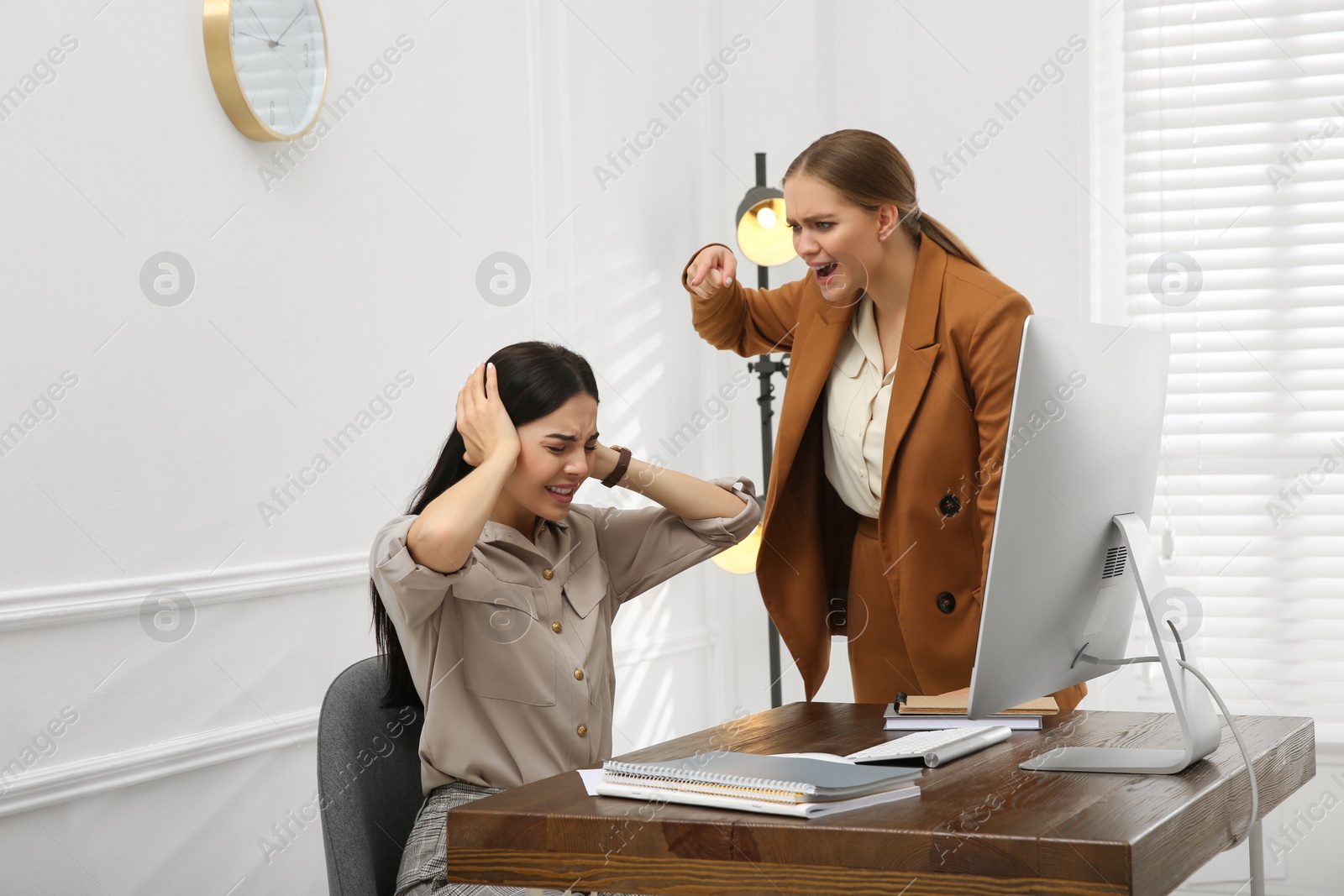 Photo of Boss screaming at employee in office. Toxic work environment