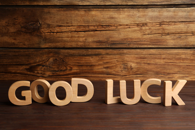 Photo of Phrase GOOD LUCK made of wooden letters on table, space for text