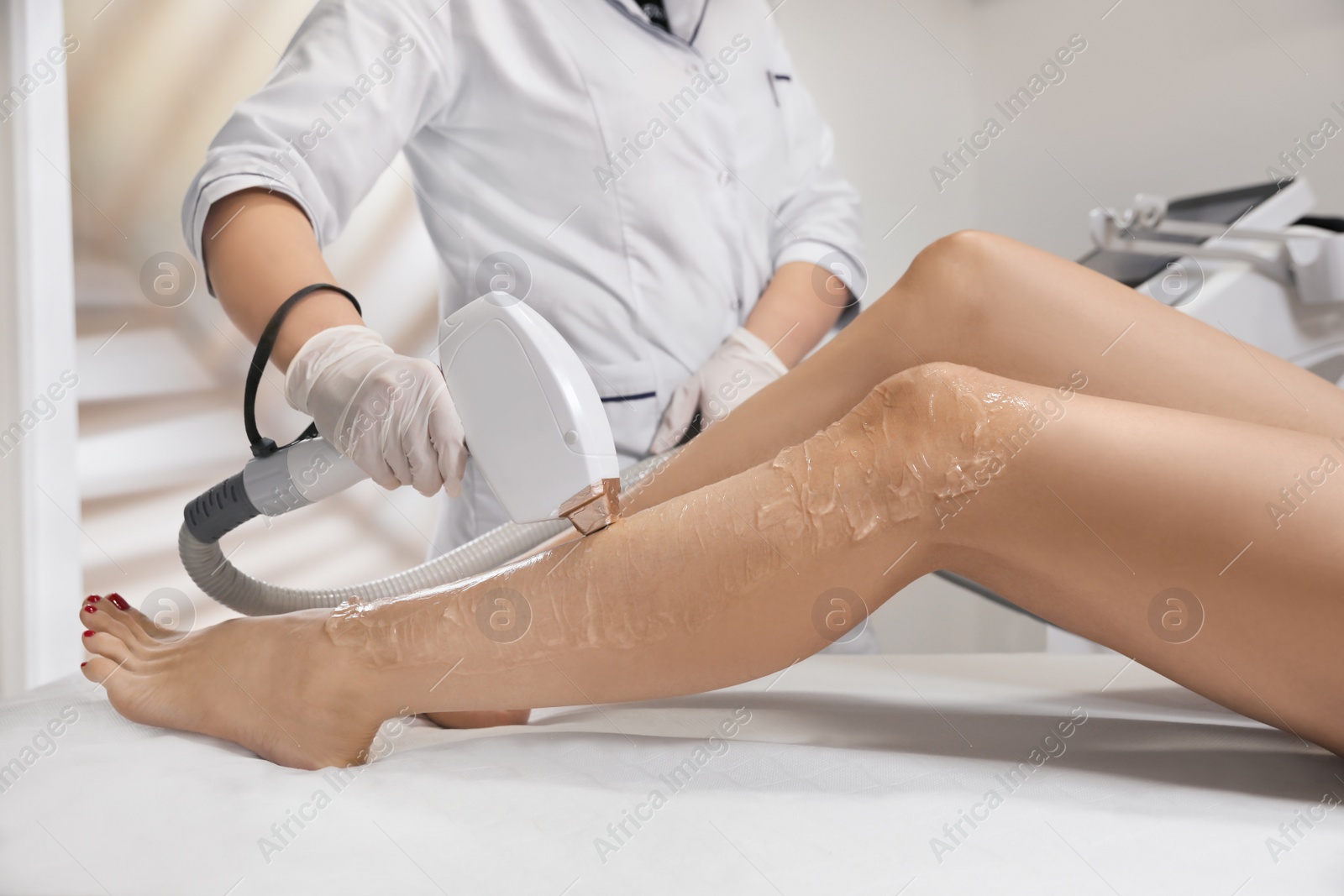 Photo of Woman undergoing laser epilation procedure in beauty salon, closeup