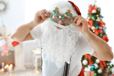 Authentic Santa Claus with funny glasses indoors