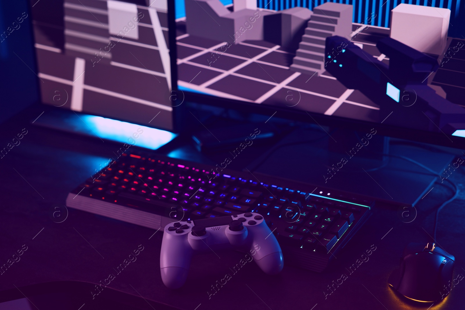 Photo of Playing video games. Computer monitor, keyboard, mouse and wireless controller on table indoors