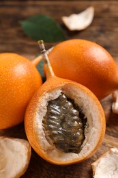 Photo of Delicious ripe granadillas on wooden table, closeup