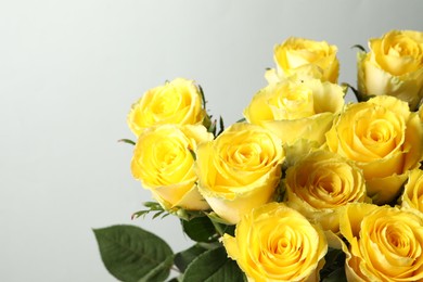 Beautiful bouquet of yellow roses on light grey background, closeup. Space for text