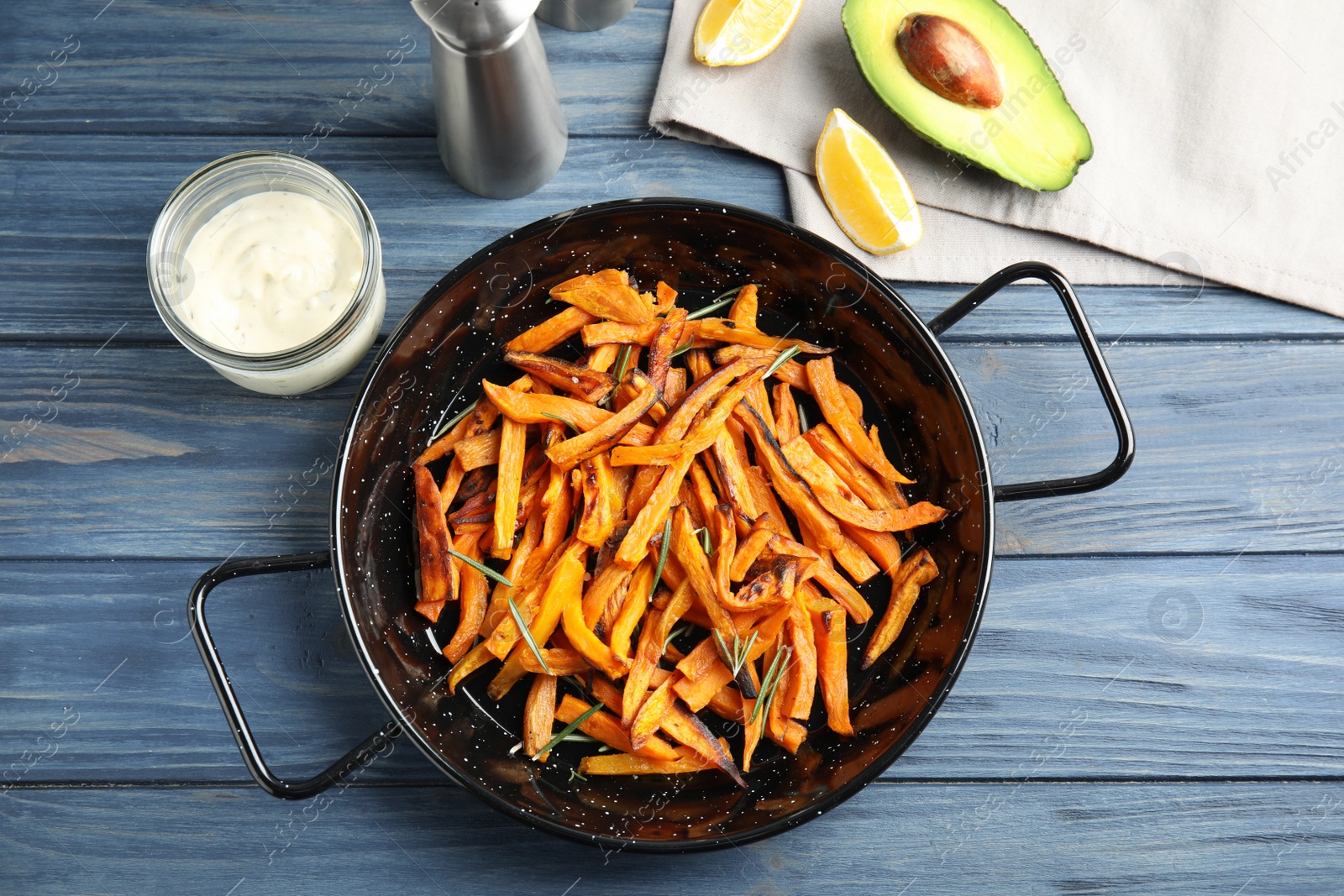 Photo of Dish with baked sweet potato slices served on wooden table, top view