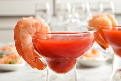 Glasses with boiled shrimps and tomato sauce on light background