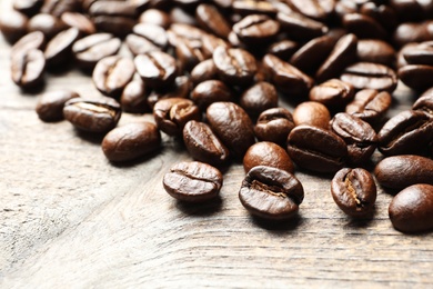 Photo of Roasted coffee beans on wooden background, closeup
