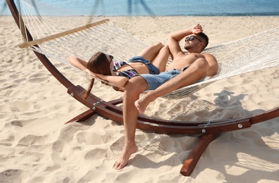 Young lovely relaxing in hammock on beach