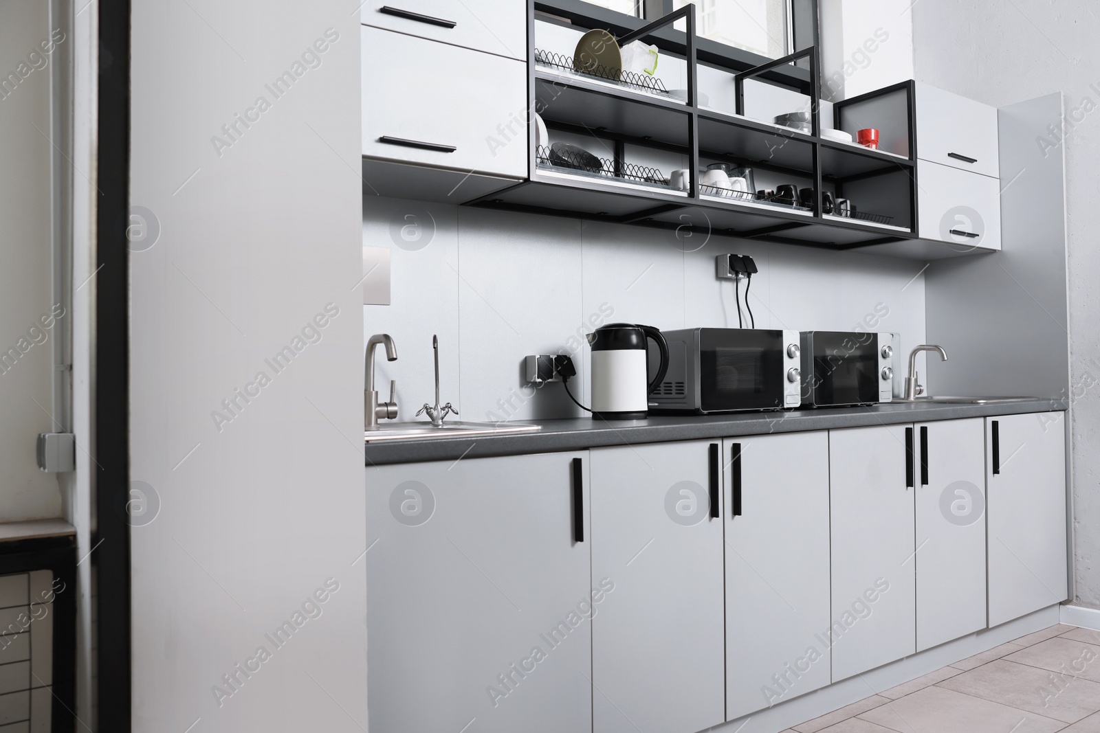 Photo of Hostel kitchen interior with modern furniture and appliances