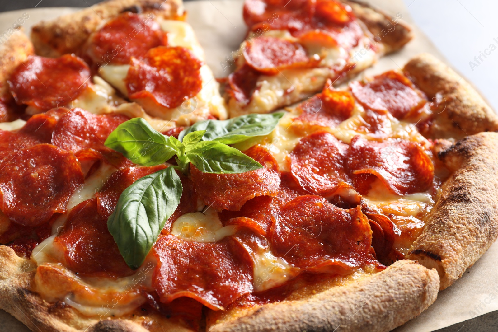 Photo of Tasty pepperoni pizza with basil on table, closeup