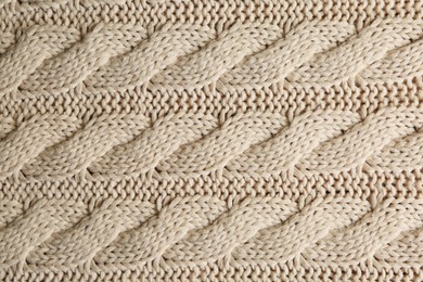 Beige knitted fabric with beautiful pattern as background, top view