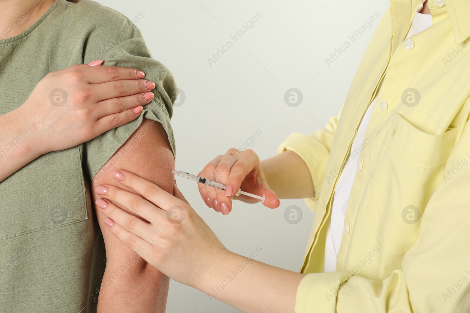 Photo of Diabetes. Woman getting insulin injection on grey background, closeup