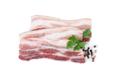 Photo of Pieces of raw pork belly, peppercorns and parsley isolated on white, top view