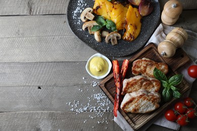 Photo of Delicious grilled meat and vegetables served on wooden table, flat lay. Space for text