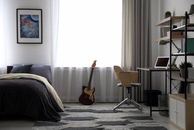 Photo of Modern teenager's room interior with workplace and bed