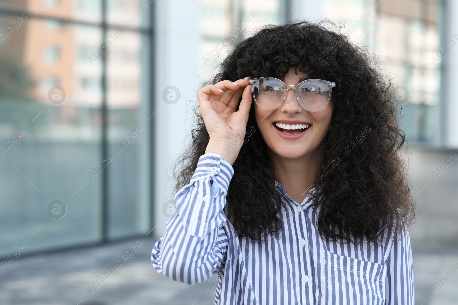 Photo of Portrait of beautiful woman in glasses outdoors. Attractive lady smiling and posing for camera. Space for text