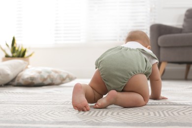 Photo of Cute baby crawling at home, focus on legs
