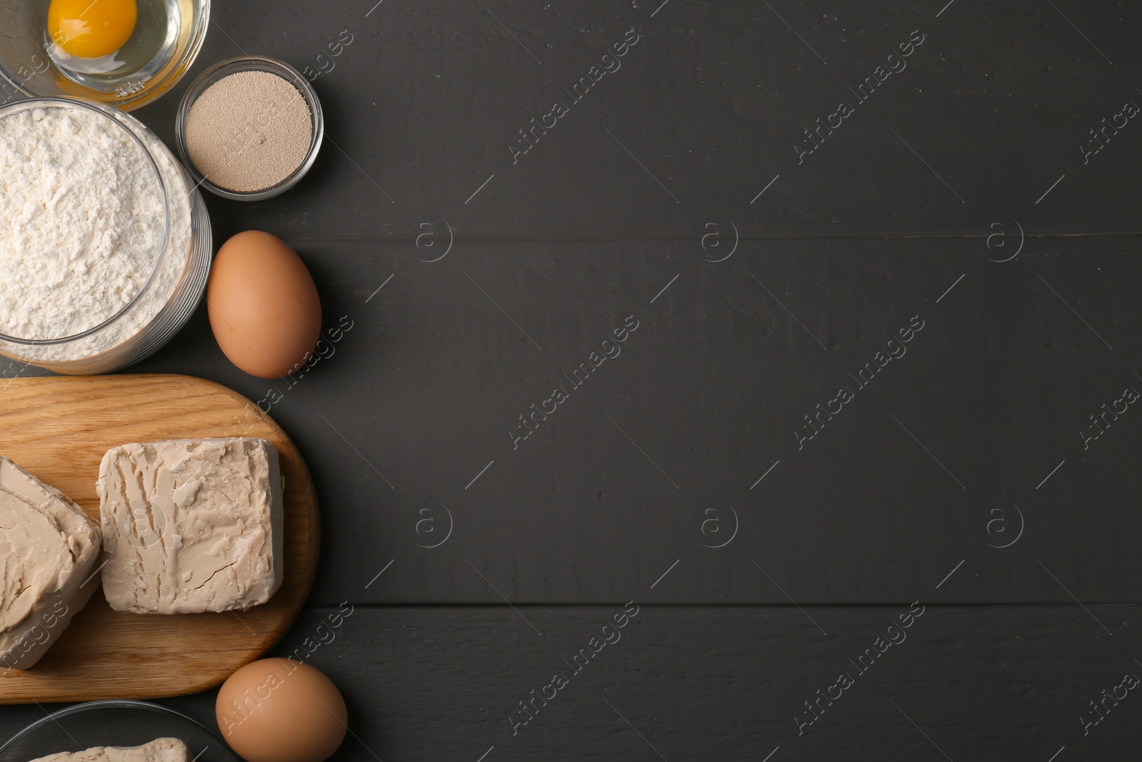 Photo of Different types of yeast, eggs and flour on grey wooden table, flat lay. Space for text