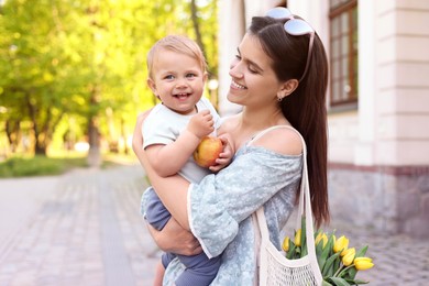 Photo of Happy mother with her cute baby on city street