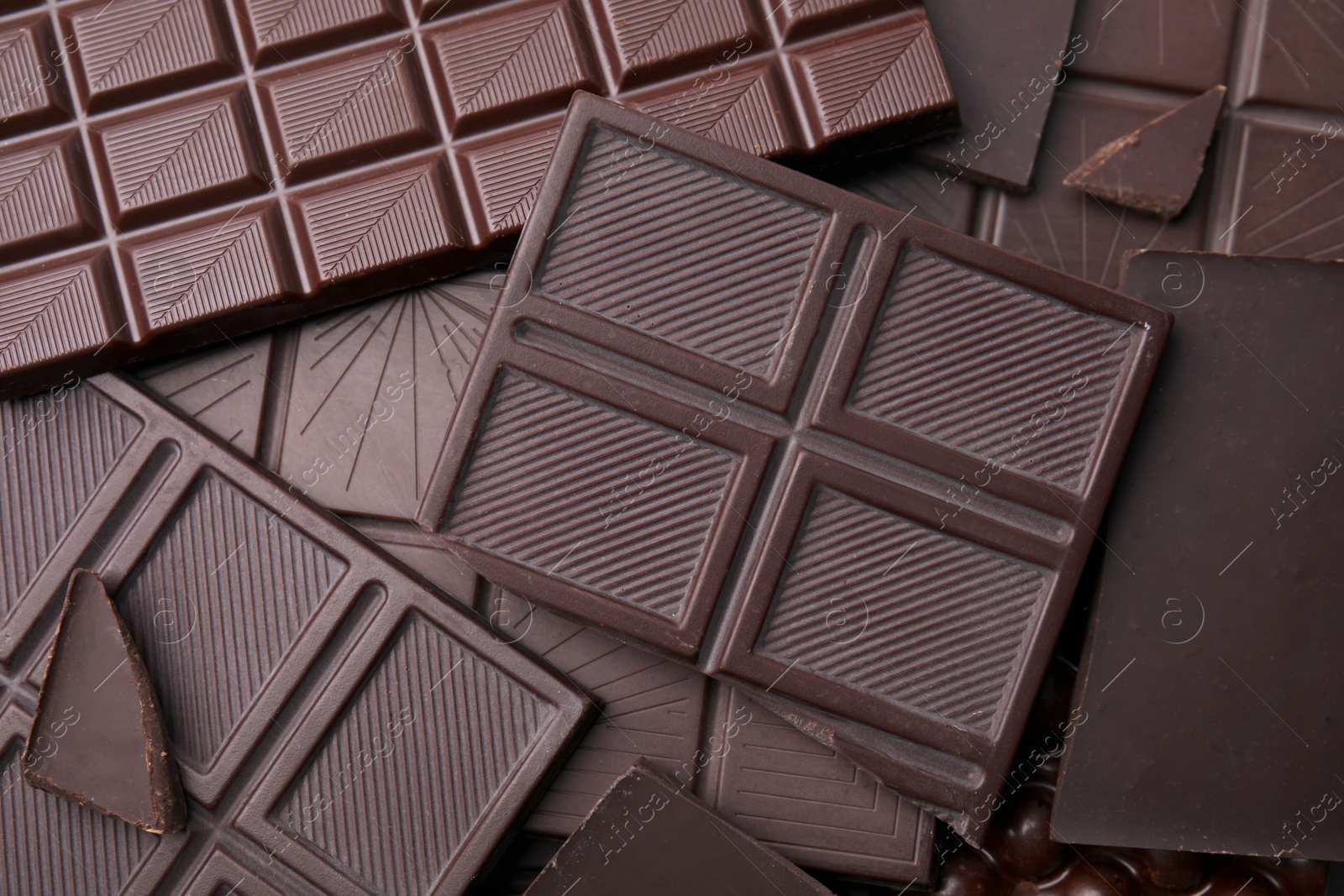 Photo of Many tasty chocolate bars as background, top view