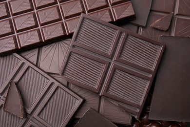 Photo of Many tasty chocolate bars as background, top view