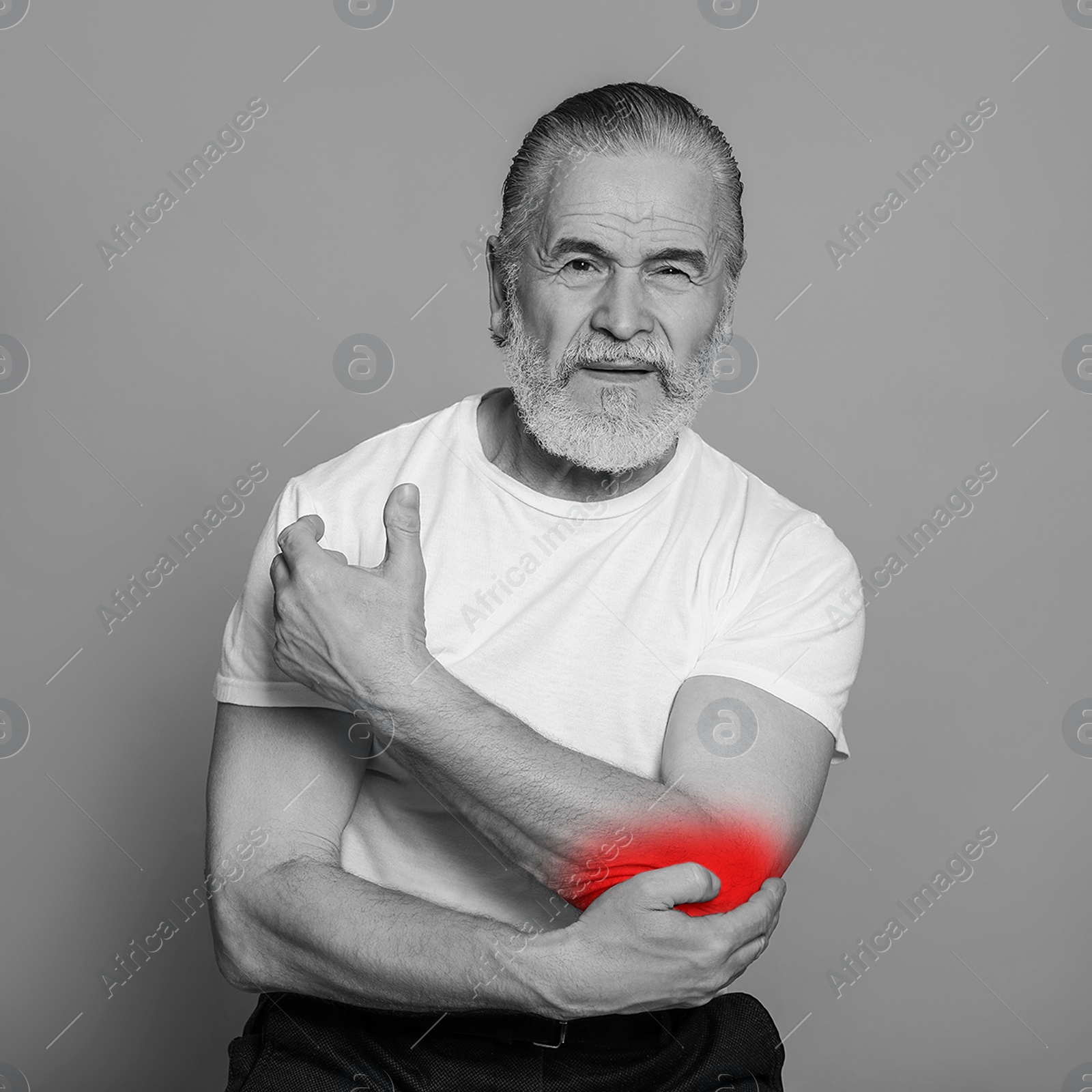 Image of Senior man suffering from rheumatism on light background. Black and white effect with red accent in painful area