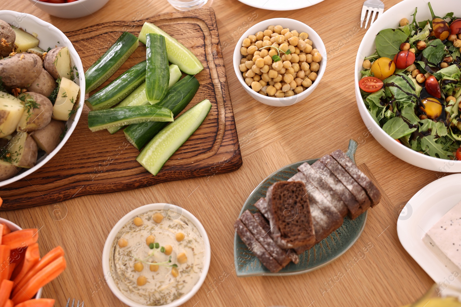 Photo of Healthy vegetarian food on wooden table, flat lay