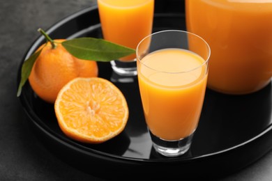 Photo of Delicious tangerine liqueur and fresh fruits on grey table, closeup