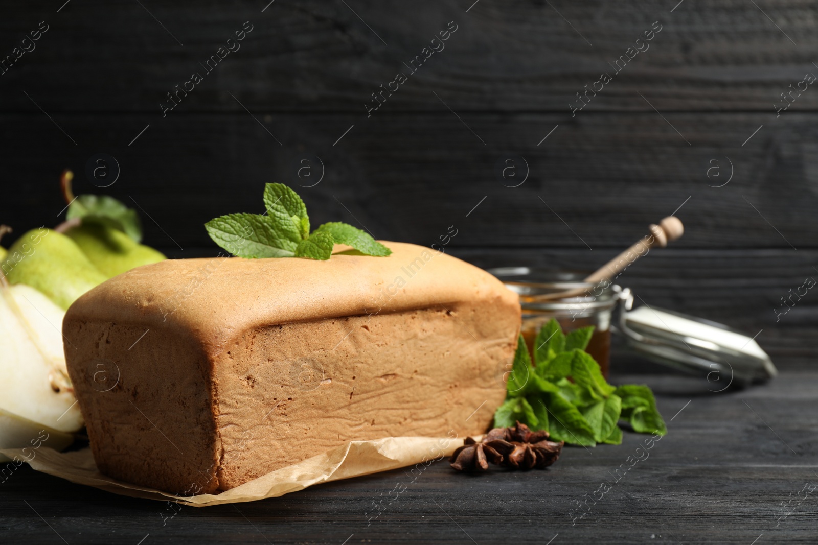 Photo of Tasty pear bread and mint on black wooden table. Homemade cake