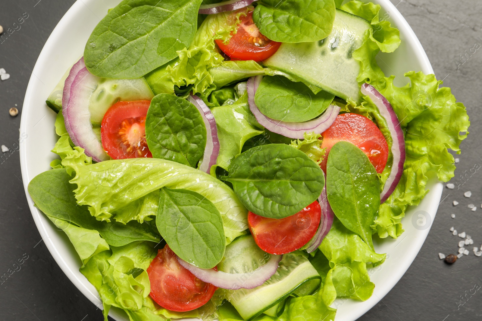 Photo of Delicious vegetable salad on grey table, flat lay