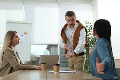 Photo of Businessman scolding employee for being late on meeting in office