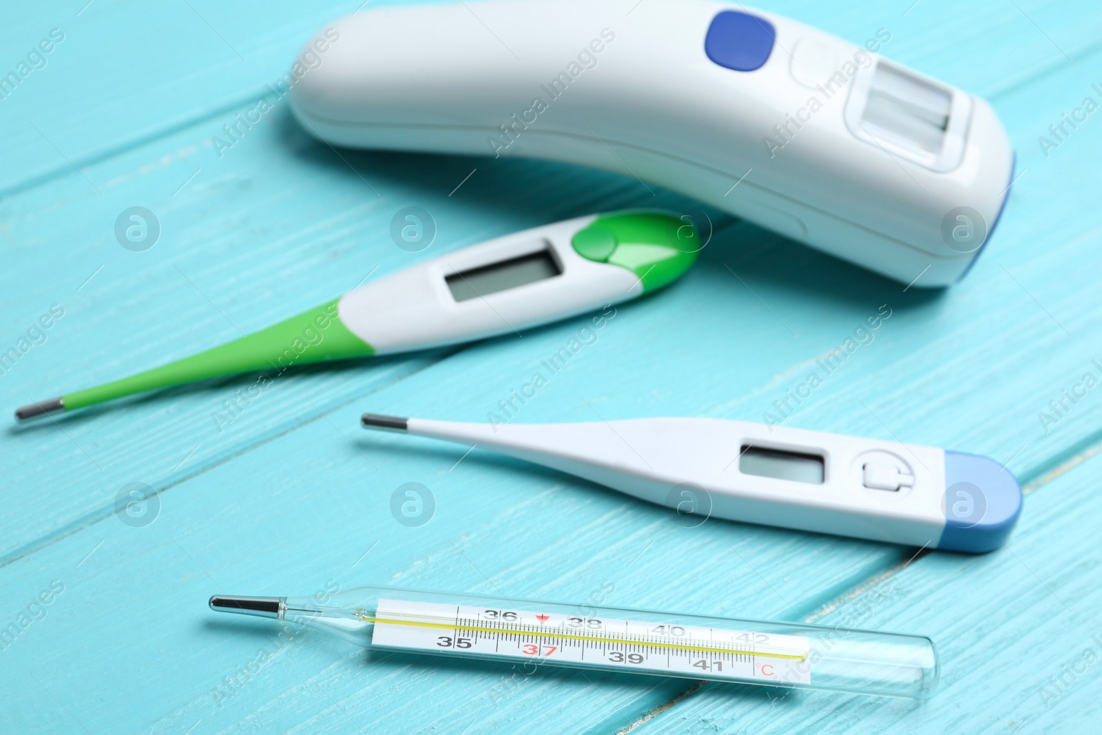 Photo of Different thermometers on light blue wooden table