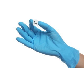 Photo of Dentist holding small plastic tooth on white background
