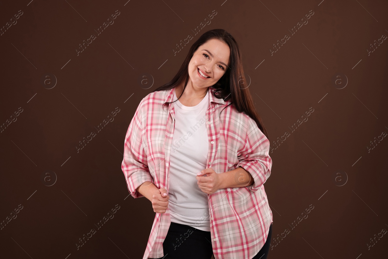 Photo of Beautiful overweight woman with charming smile on brown background