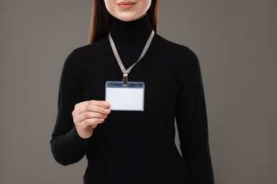 Photo of Woman with blank badge on grey background, closeup