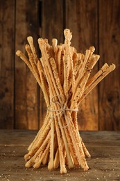 Photo of Bunch of delicious grissini sticks on wooden table