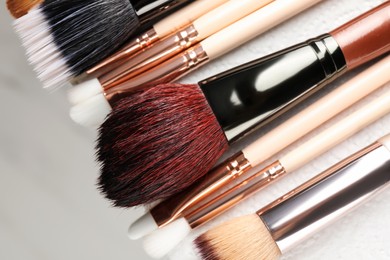 Photo of Set of different makeup brushes drying after cleaning on paper towel, closeup